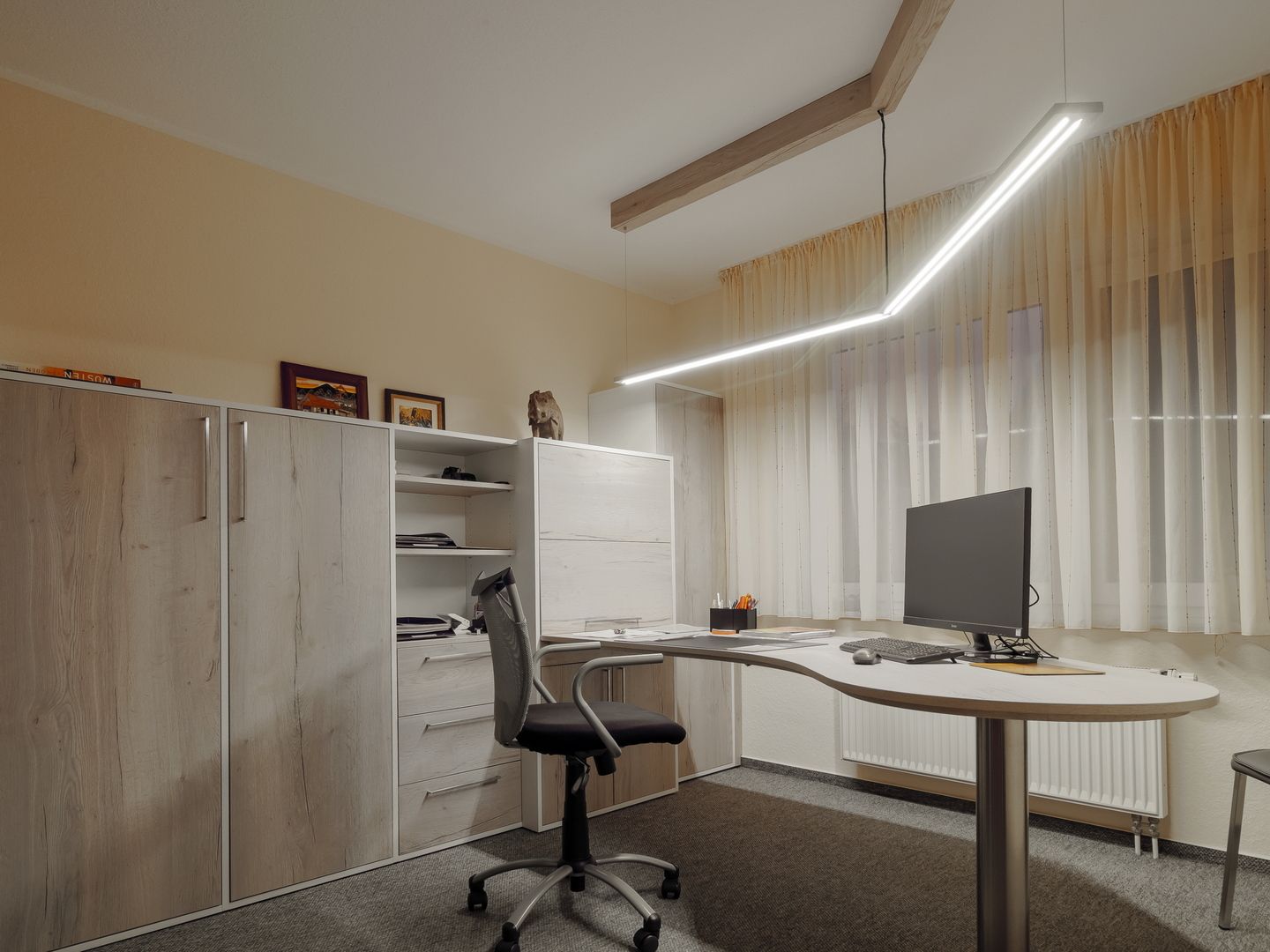 Büro mit Holzmöbeln, ergonomischem Stuhl und stimmungsvoller Beleuchtung