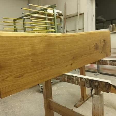 Großes Holzbrett auf einem Sägebock in einer Werkstattumgebung