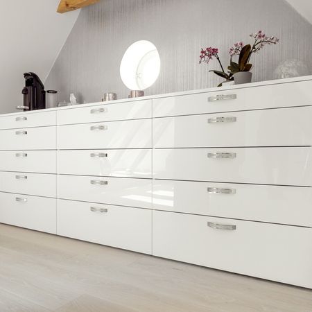 Weiße Kommode mit dekorativen Elementen auf der Oberseite