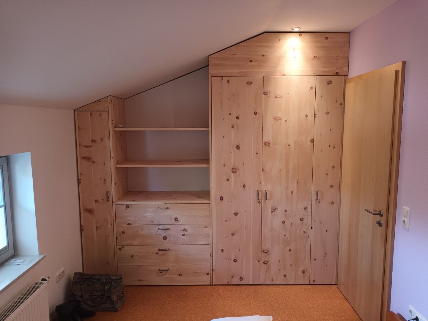 Schrank und Regal aus Holz unter einer Dachschräge