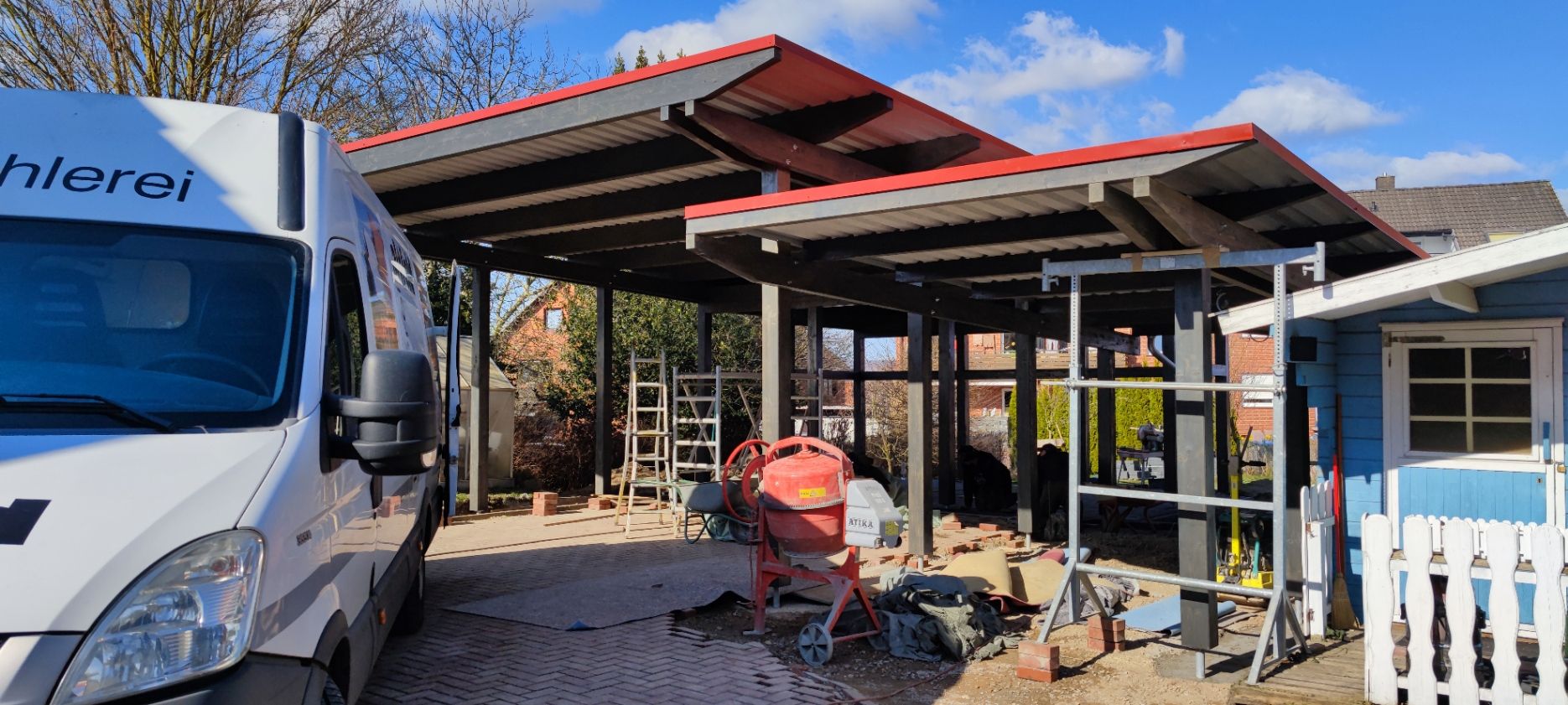 Unfertige Carport-Konstruktion mit einem Lieferwagen auf der linken Seite